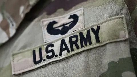 NurPhoto via Getty Images A close up of a badge on military fatigues that says "US Army"