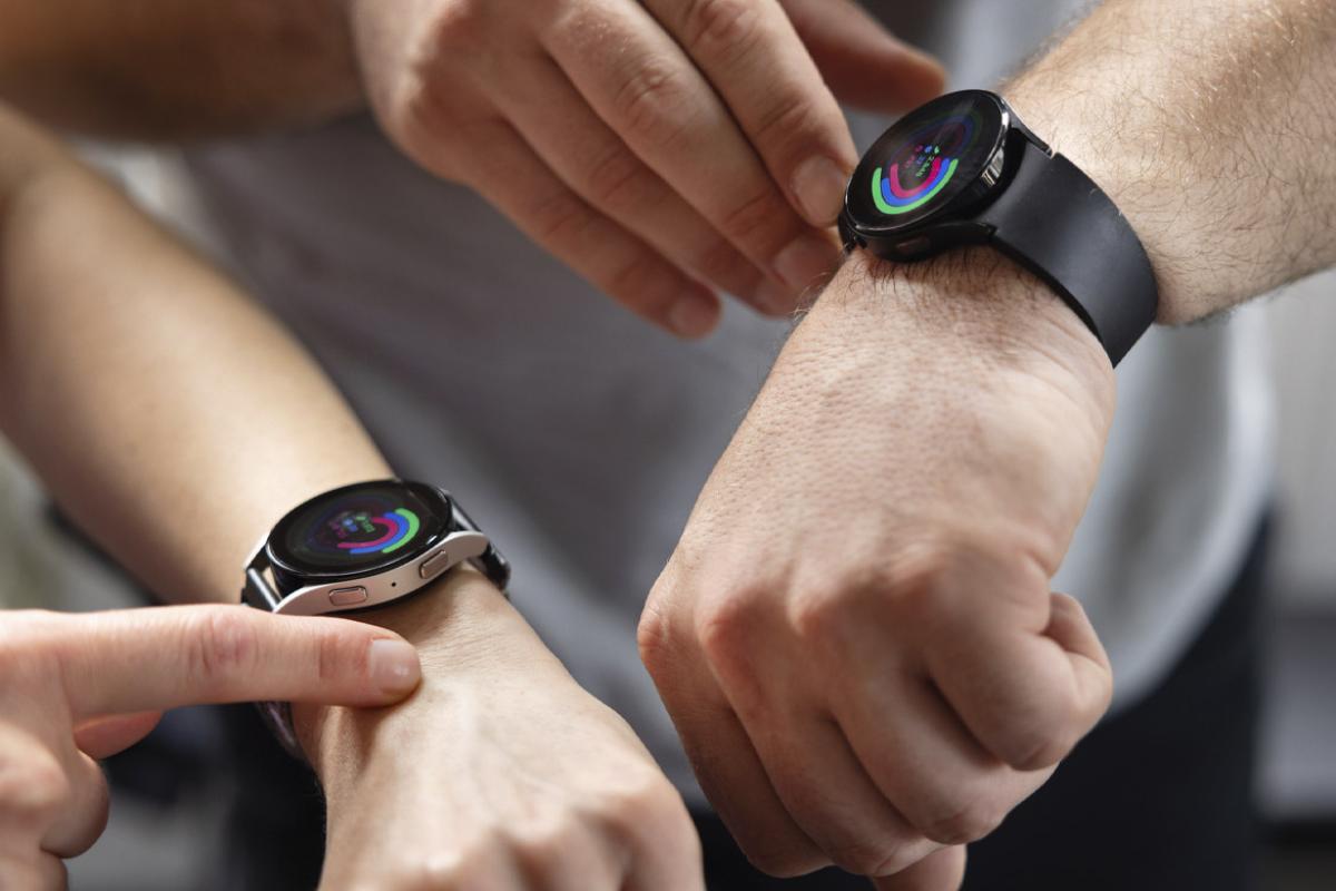 Fingers point to activity trackers on smartwatches