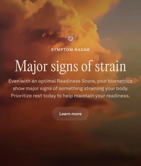 A screenshot of an Oura "Major signs" notification. In white writing against a backdrop of a large white cloud in a blue sky, it reads: Major signs of strain. Even with an optimal Readiness Score, your biometrics show major signs of something straining your body. Prioritize rest today to help maintain your readiness.