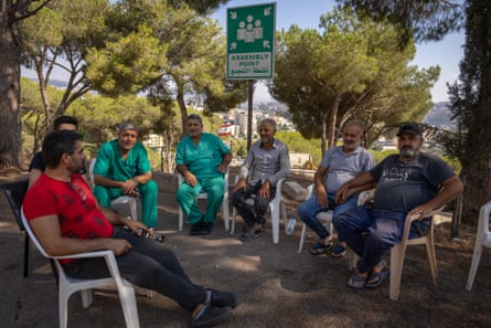 Medics gather in the shade of a tree during their break outside the Nabih Berri governmental hospital.