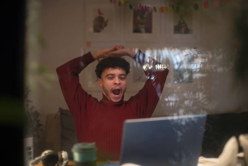 Tired young man working late from home on laptop in office window. (Photo by Sam Edwards/CAIA IMAGE/SCIENCE P / NEW / Science Photo Library via AFP)