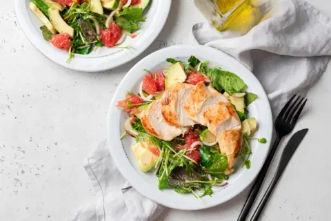 Arx0nt Grilled chicken salad with avocado on a white plate