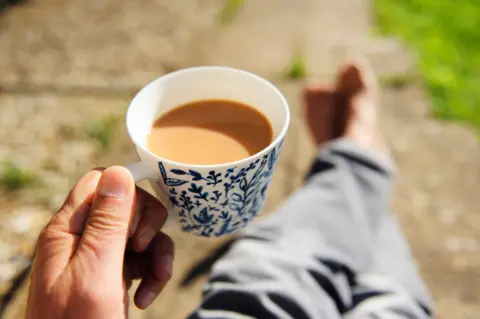 Gary Yeowell Close-up of senior person's hand holding a cup of tea