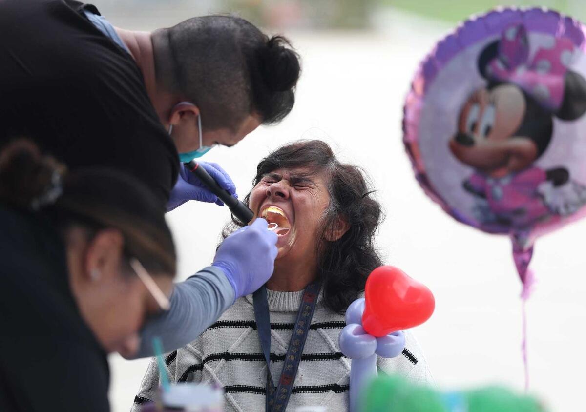 Clients take advantage of dental health screenings at Delhi Center in Santa Ana on Monday.