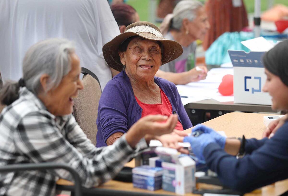 Clients take advantage of health screenings at Delhi Center in Santa Ana on Monday.