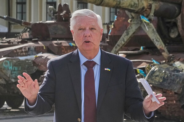 U.S. Sen. Lindsey Graham, R-S.C. answers a question from a media member near damaged Russian vehicles on display in central Kyiv, Ukraine, Friday, July 10, 2026. (AP Photo/Efrem Lukatsky)