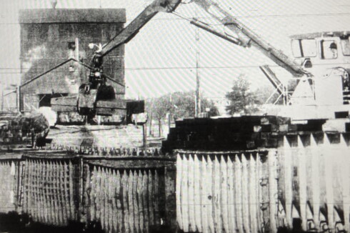 A backhoe loads up railroad ties.