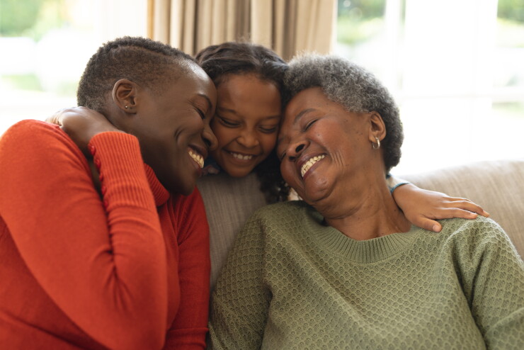 Three generations, hugging, smiling