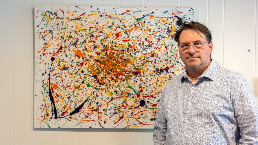 Ryan Welch stands in front of a painting he and his son made as a gift for Welch’s wife in their Indianapolis home on Thursday May 14, 2026. The Welchs’ son came out as trans during the pandemic.