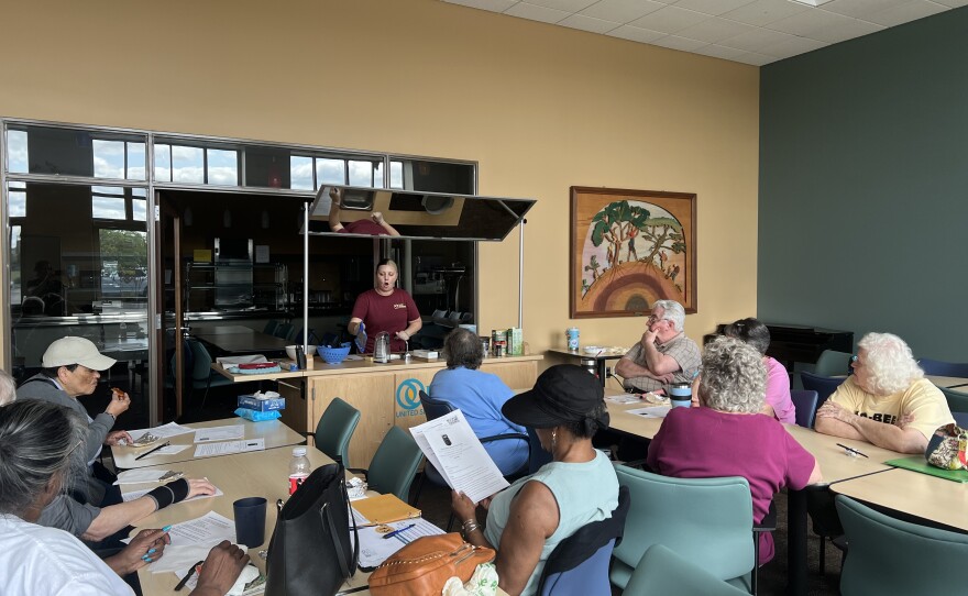 More than 10 class members learn how to make budget-friendly meals from Natasha Ridenour in a community room at United Senior Services