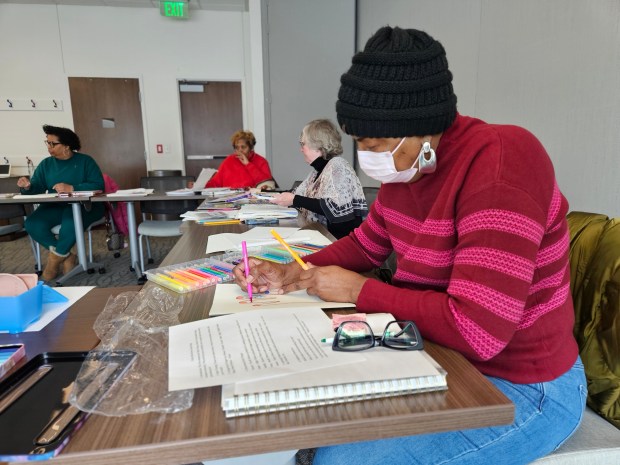 Glenda Ashe colors a tracing of her hand in a mindfulness class at Sentara Brock Cancer Center featuring art activities. (Courtesy Sentara Health)