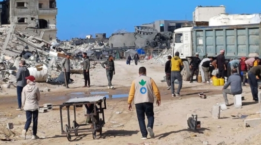 Action Against Hunger aid worker walking amidst rubble in Gaza in January 2025.