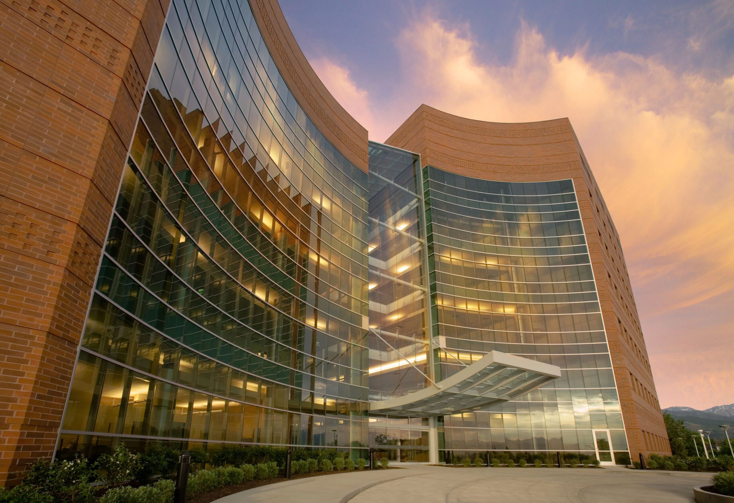 A several building at sunset with a wall of windows