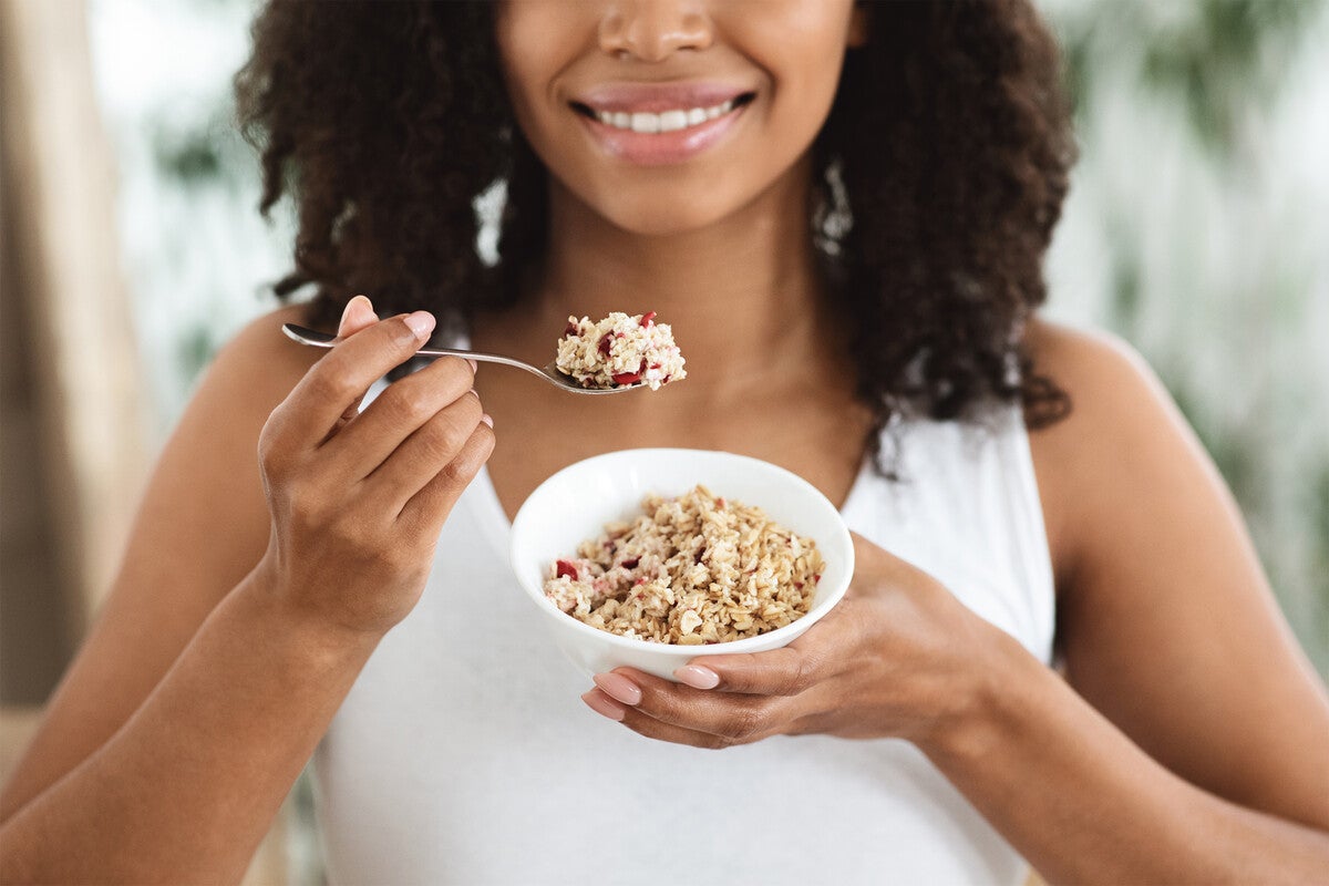 Woman eating bowl of oats