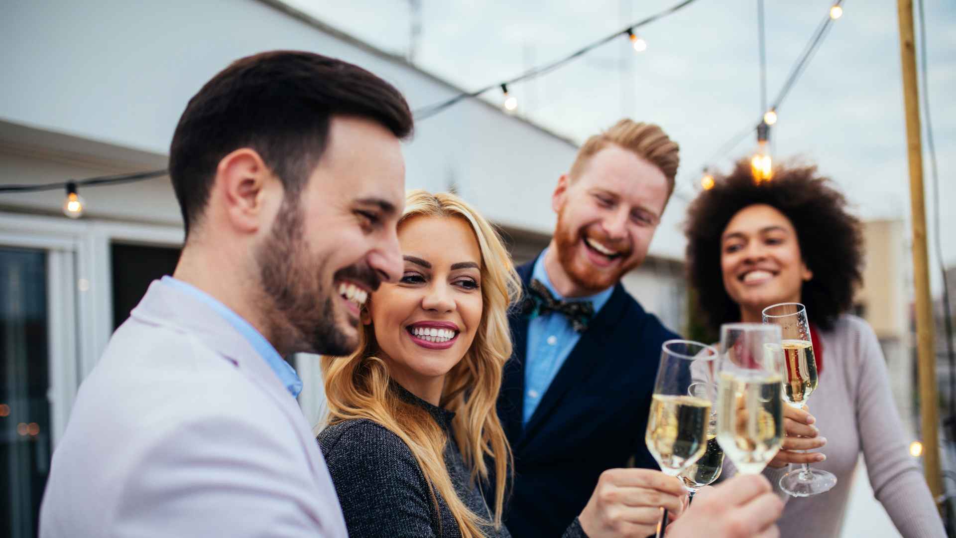Discover a group of wealthy people or friends celebrating outdoors with glasses of champagne.