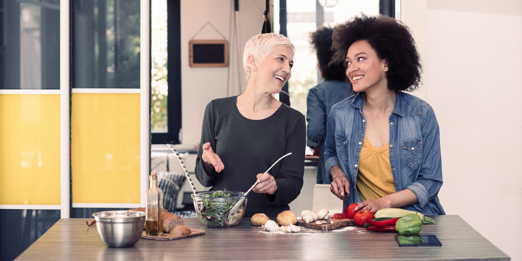 Happy mixed race women preparing healthy meal.
