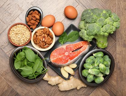 Variety of foods that support brain health, with salmon, walnuts, shellfish and leafy greens