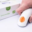 A person holding a Dexcom G6 Continuous Glucose Monitoring device with its packaging in the background.