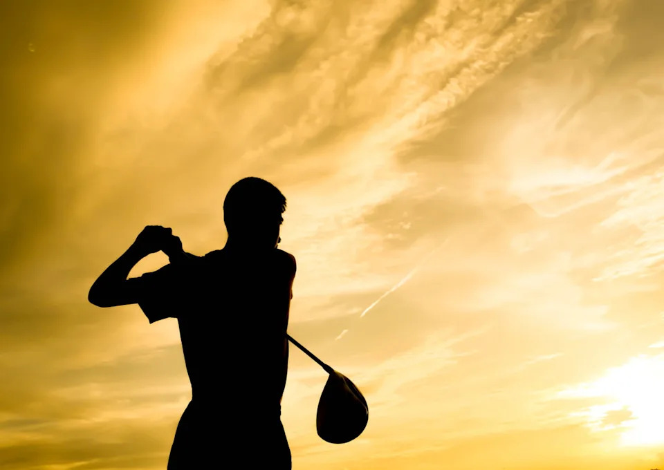 Golfer silhouette swinging at sunset design background, Golfer silhouette swinging at sunset design background ©IMAGO/Dreamstime