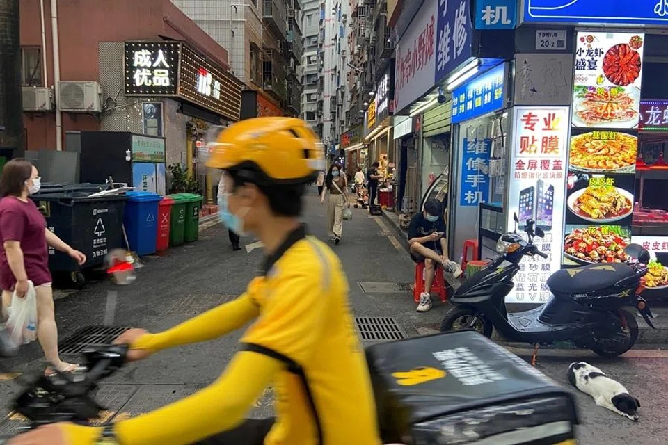 A food delivery worker rides past an urban village in Shenzhen's Futian district, Guangdong province, China, on 31 May 2022.