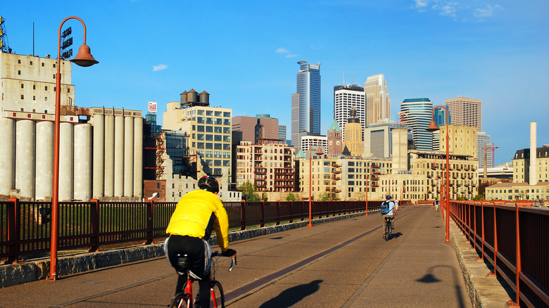 People bike on Stone Arch Bridge towards downtown Minneapolis