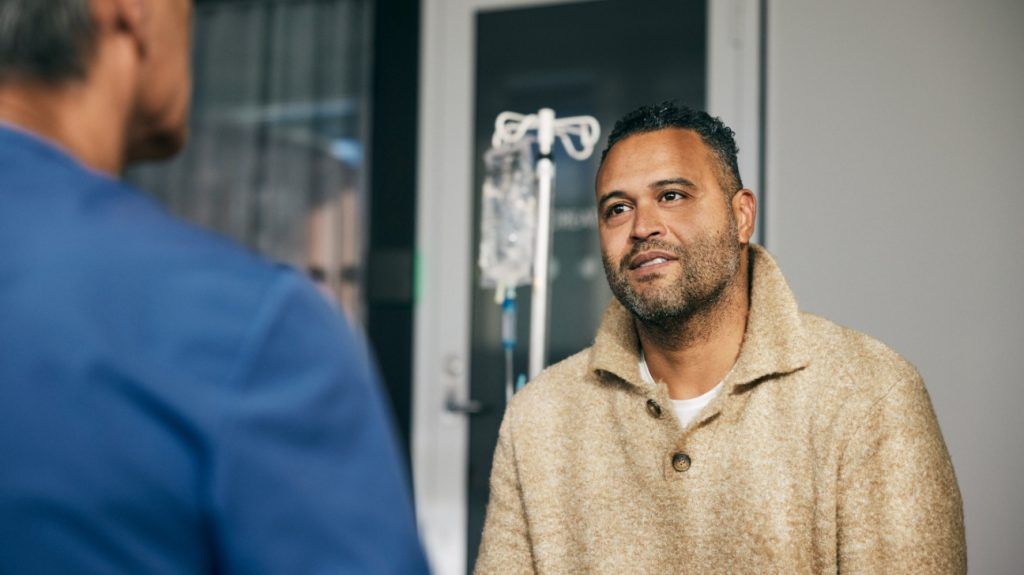 Man listening to doctor's advice while sitting in clinic at hospital