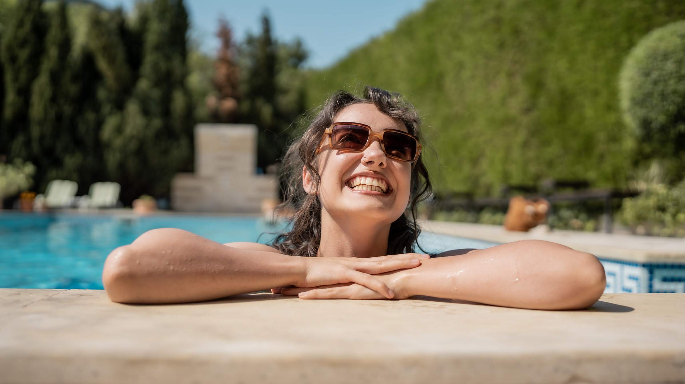 woman wearing sunglasses sitting in swimming pool