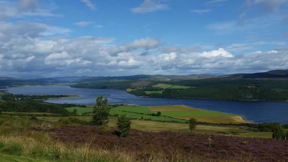 Struie in the Scottish Highlands. A picture of the green landscape with a blue sky and river.
