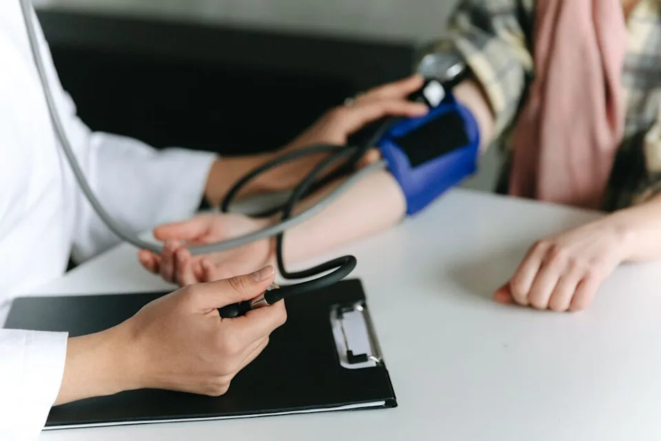 Close-up of a medical professional measuring a patient's blood pressure at a clinic.