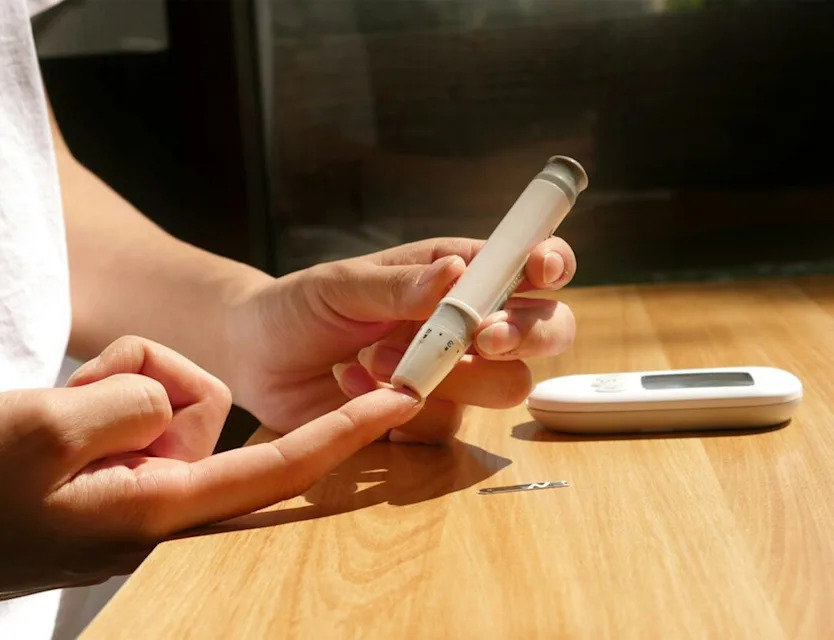 Person using glucometer to take blood sugar levels