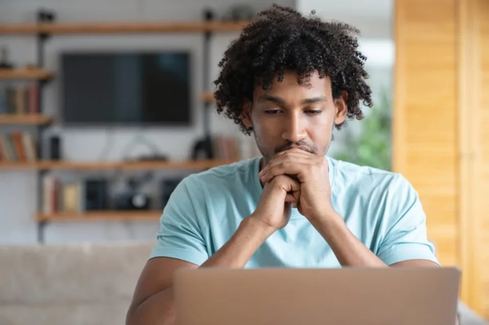 An investor looks pensive behind a computer screen.