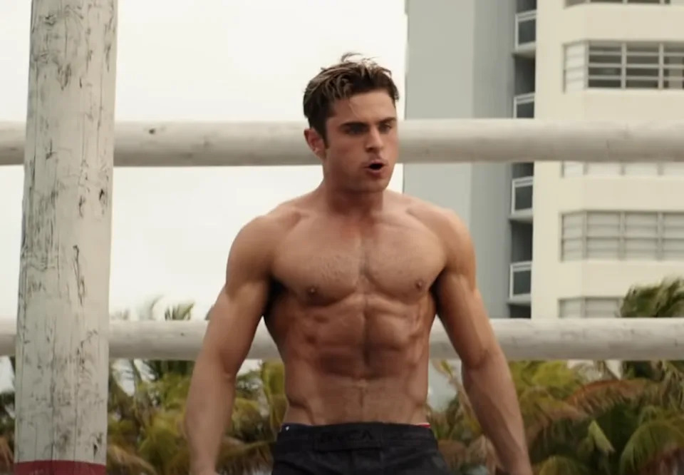 Zac Efron shirtless in Baywatch; his body is toned to an extreme degree