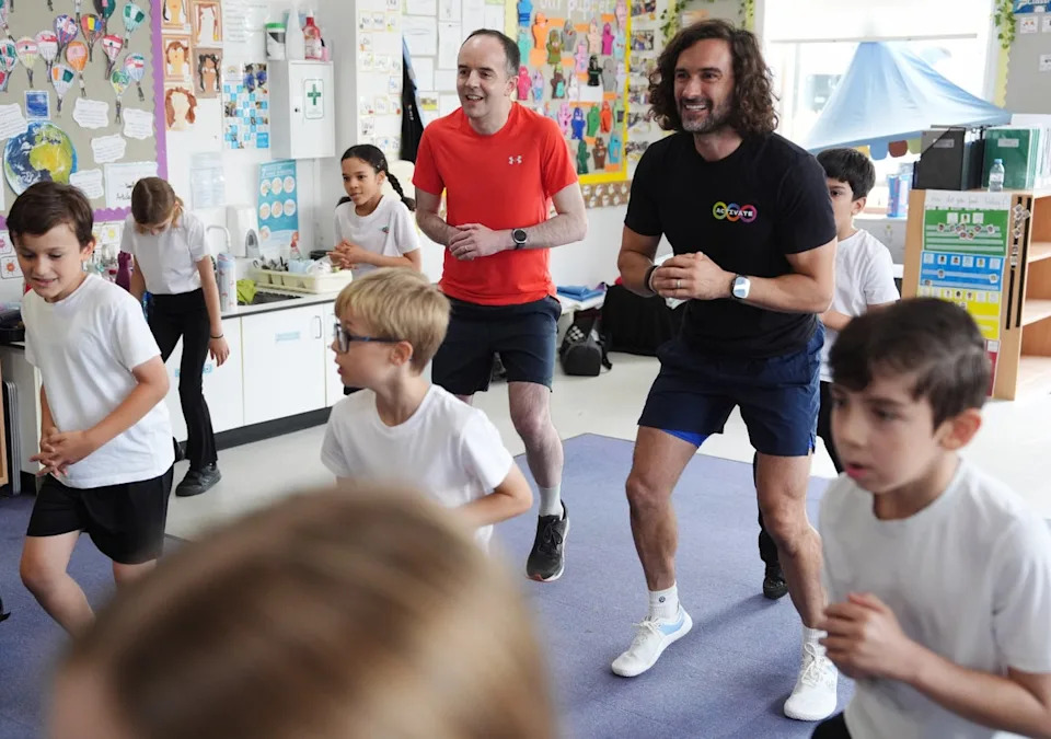 Joe Wicks and Health Secretary James Murray meet and exercise with year 2 and 3 pupils during a visit to Colindale Primary School in London to launch the fitness coach's new series of kids' workout programme Activate (PA)