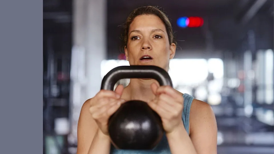 Woman holding kettlebell in front of her chest for a 20-minute kettlebell workout.