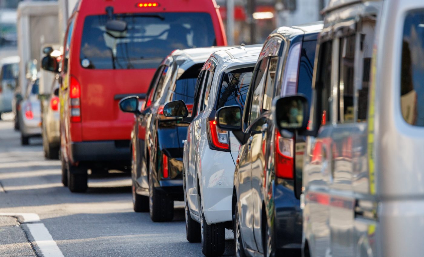 Cars queued in traffic with brake lights on, the kind of tire wear and pollution linked to Alzheimer's risk.