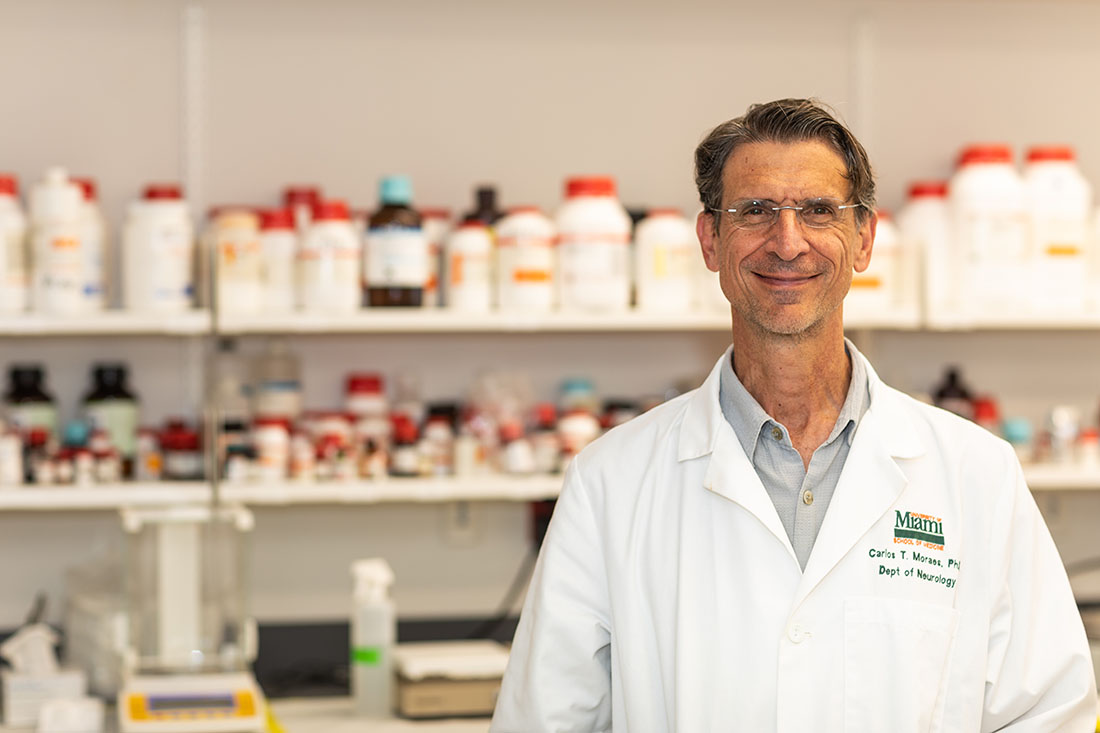 Dr. Carlos Moraes in his white coat, in the lab
