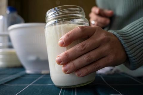 Hand holding mason jar of kefir