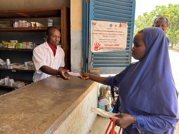A patient presents her prescription to the pharmacist to get medicines after consulting at the Ouadda Health Center. UNOCHA/Maxime Nama