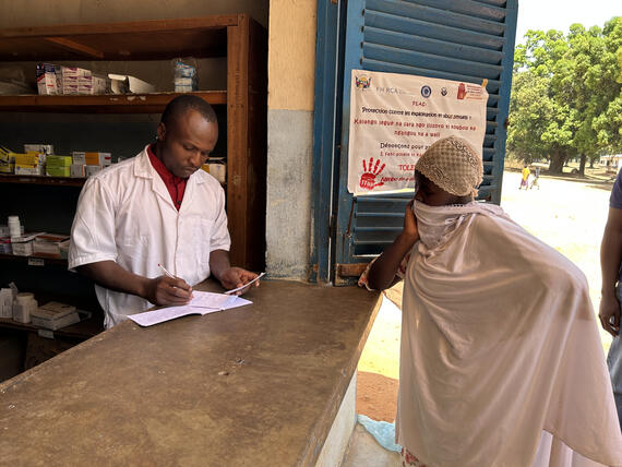 Amne Izadid presenting her prescription to the pharmacist to get medicines after consulting at the Ouadda Health Center. UNOCHA/Maxime Nama