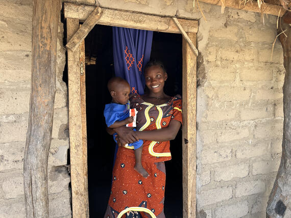 Laurène holds her son, Gervais, as he eats ready-to-use therapeutic food as part of his nutrition treatment. Photo: UNOCHA/Maxime Nama