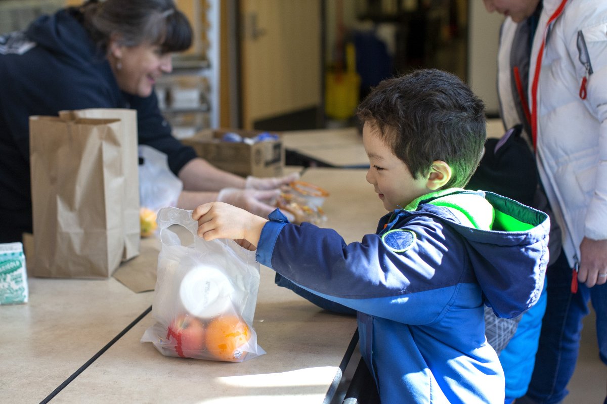 SEATTLE, WA - MARCH 18: Tyden Brownlee, 5, picks up a free school lunch at Olympic Hills Elementary School on March 18, 2020 in Seattle, Washington. As a result of all schools in Washington state being closed due to the COVID-19 outbreak until at least April 27th, Seattle Public Schools is providing carry-out meals to students during lunch hours. (Photo by Karen Ducey/Getty Images)