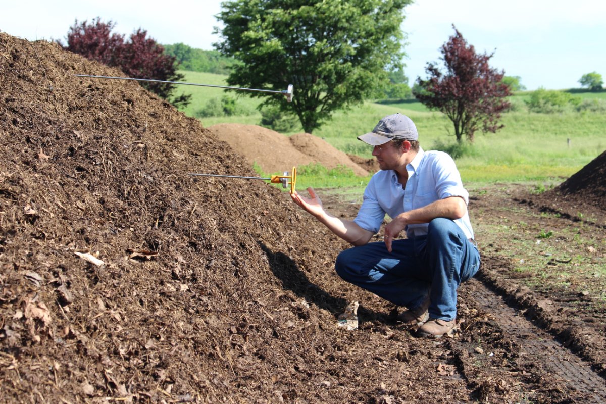 Rick Carr takes the temperature of a backyard compost pile at Rodale Institute.