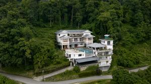a photo of a luxury rehab centre for deaddiction and mental health issues, situated in the eastern himalayas, surrounded by lots of tall trees