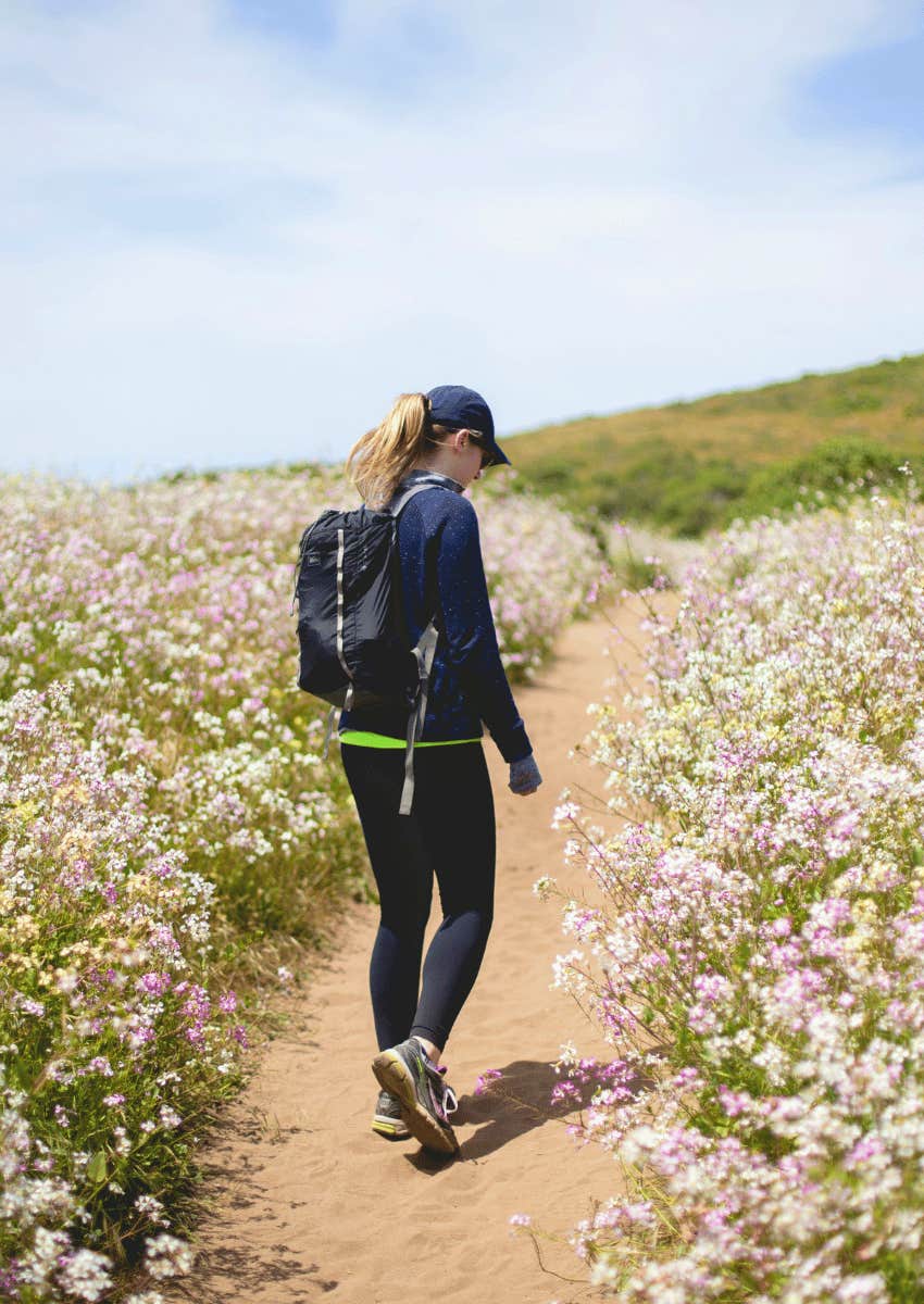 woman walking down a nature path