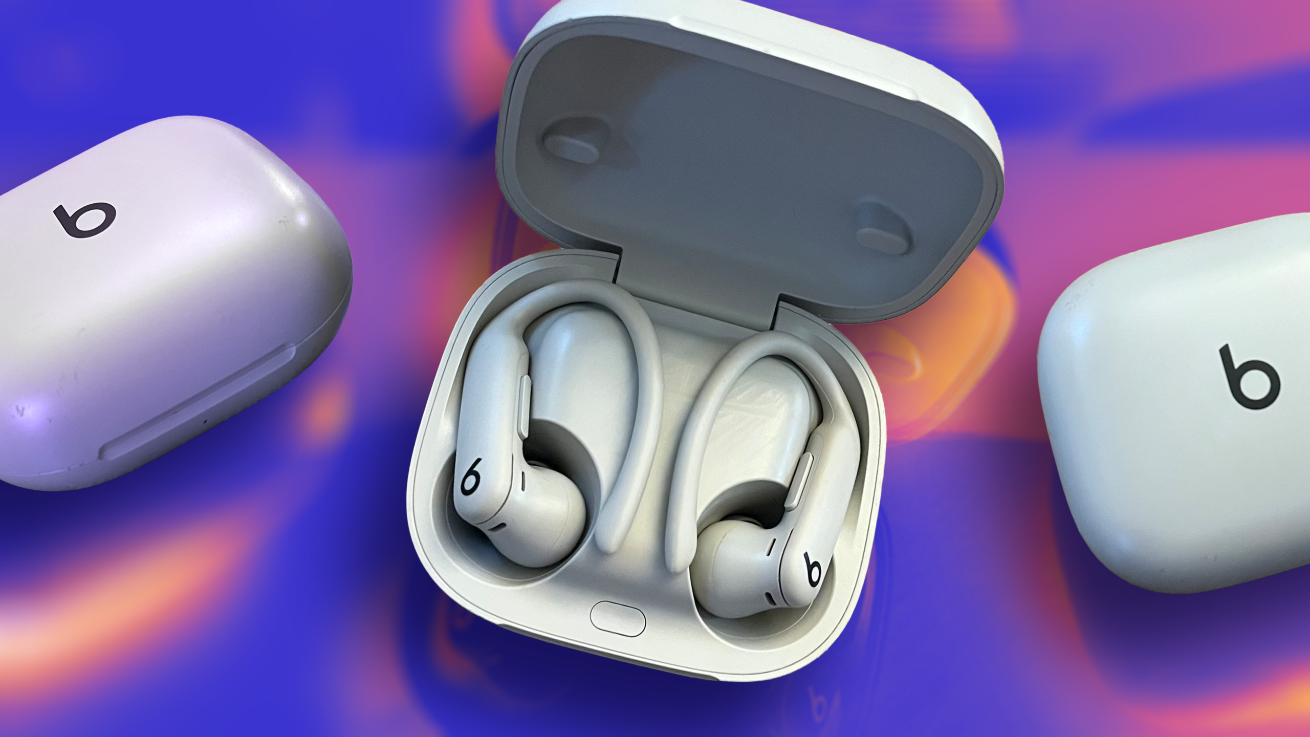 Pair of powerbeat pro 2 earbuds in a case on a purple and orange background