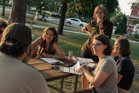 A group of people sitting around a picnic table.