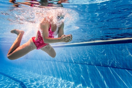 An underwater view of a woman swimming breaststroke.