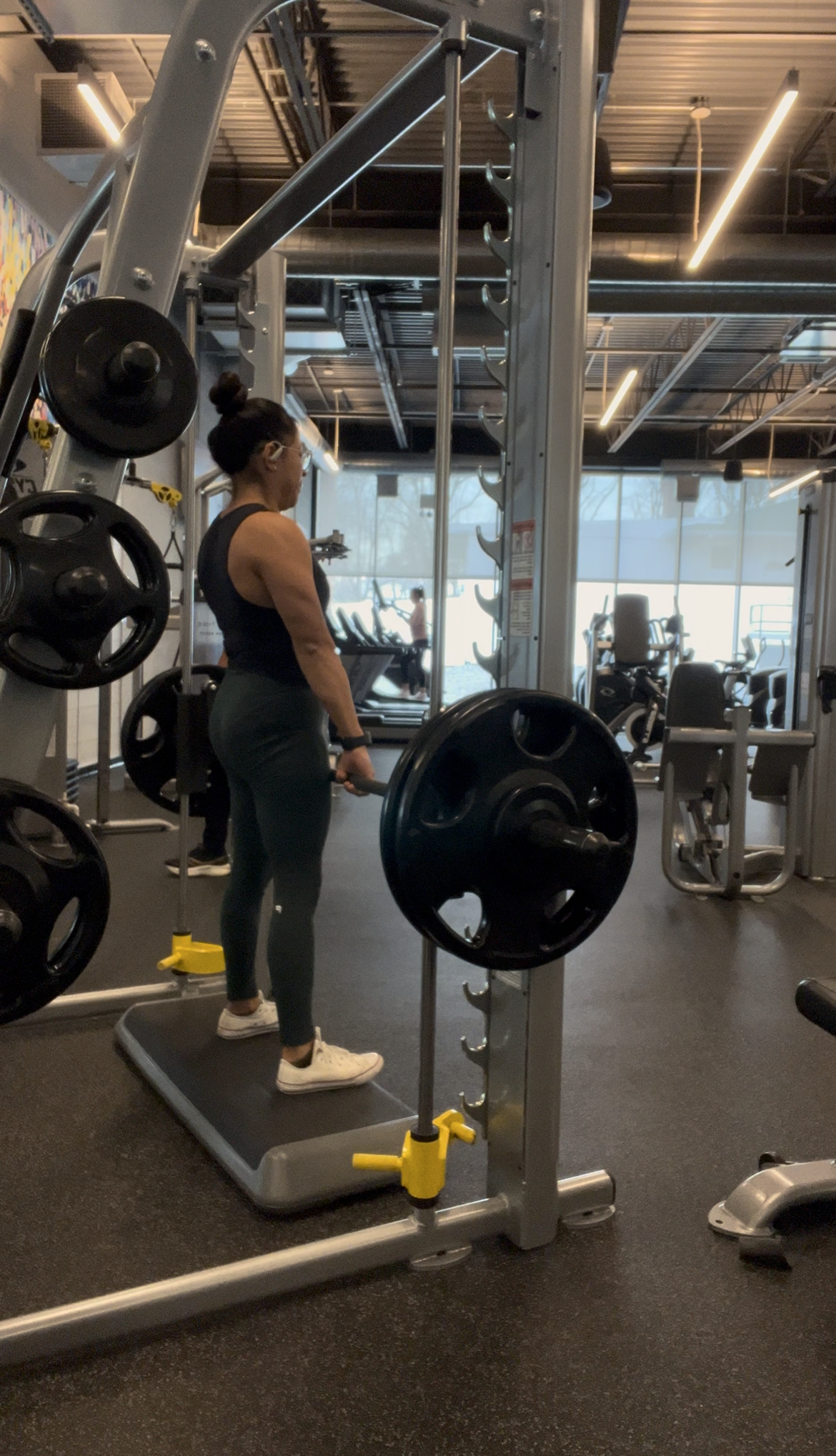 Woman lifting weights on the smith machine