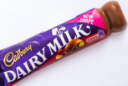 New shape Cadbury Dairy Milk fruit & nut chocolate bar with wrapper undone to show contents set on white background