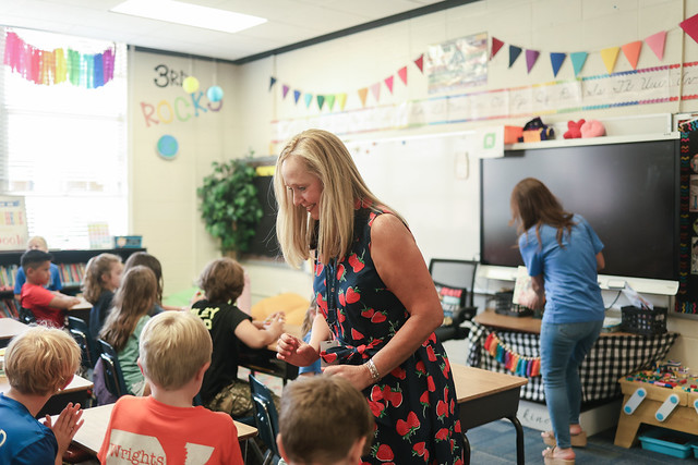 Ashley Powell is pictured interacting with students inside a classroom.
